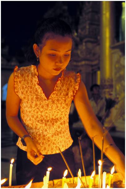 jeune femme allumant des bougies � la pagode Shwedagon au Myanmar